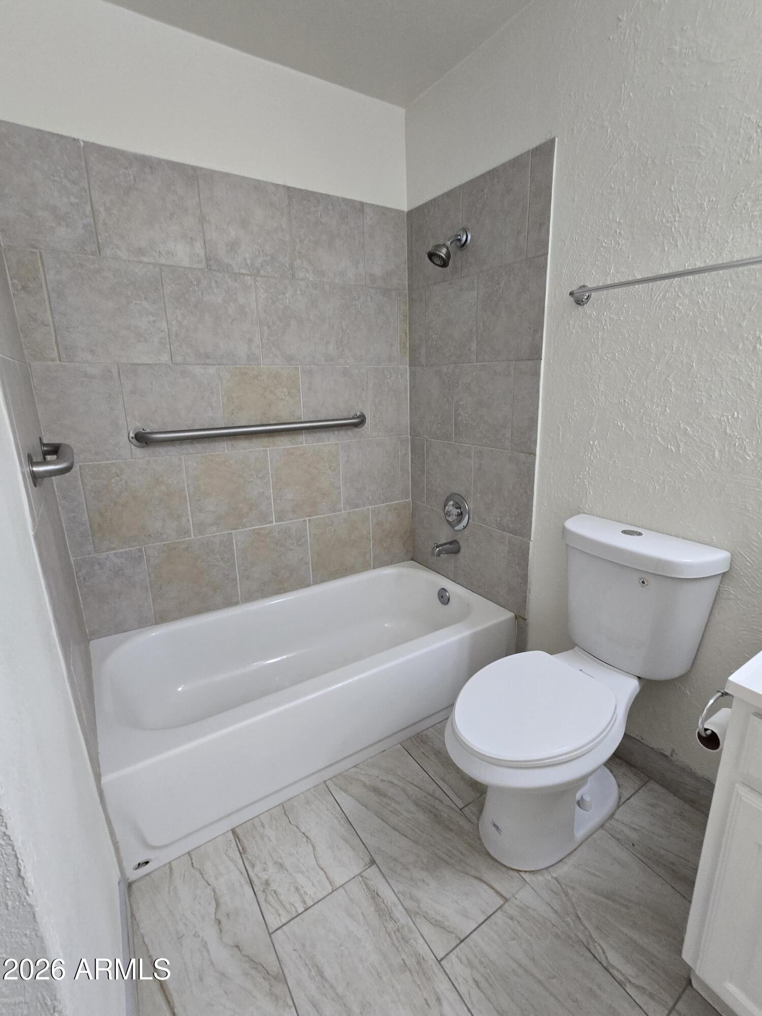 6512 North 41st Avenue Phoenix, AZ 85019 - Photo 17 of 24 a white toilet sitting next to a bath tub and a shower