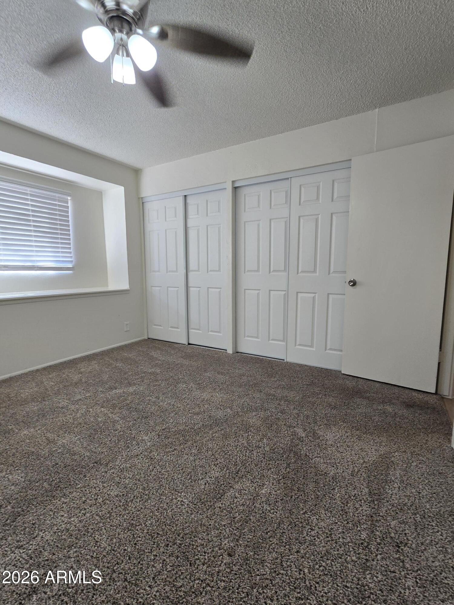 6512 North 41st Avenue Phoenix, AZ 85019 - Photo 19 of 24 a view of an empty room with window and wooden floor