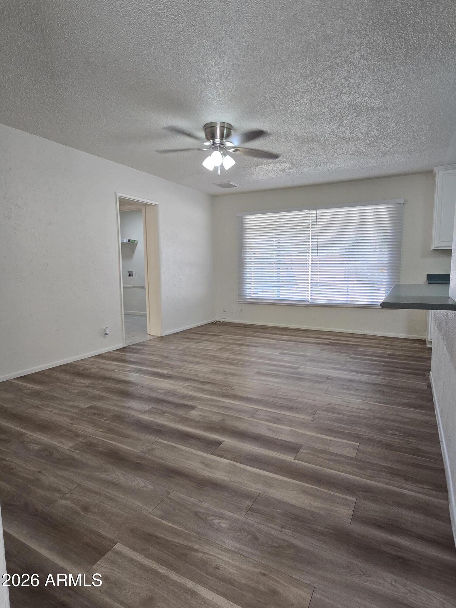 6512 North 41st Avenue Phoenix, AZ 85019 - Photo 6 of 24 a view of an empty room with wooden floor and a window
