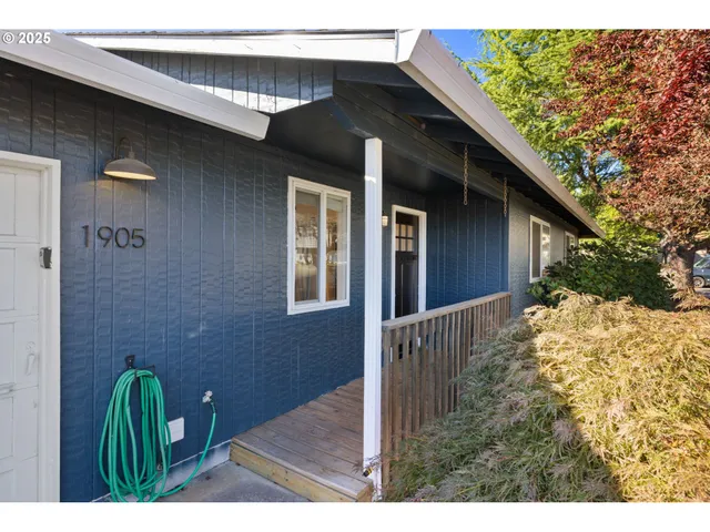 a picture of a room with a hanging light and hardwood floor