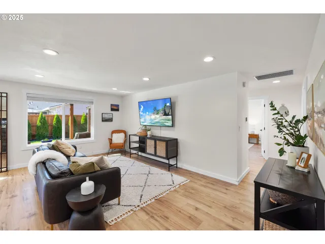 a living room with furniture a flat screen tv and a couch
