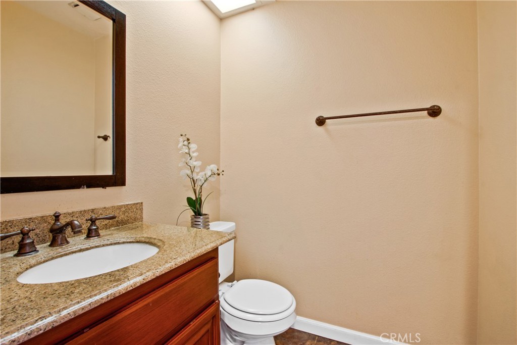 3117 Antler Road Ontario, CA 91761 - Photo 10 of 16 a bathroom with a granite countertop sink toilet and a mirror