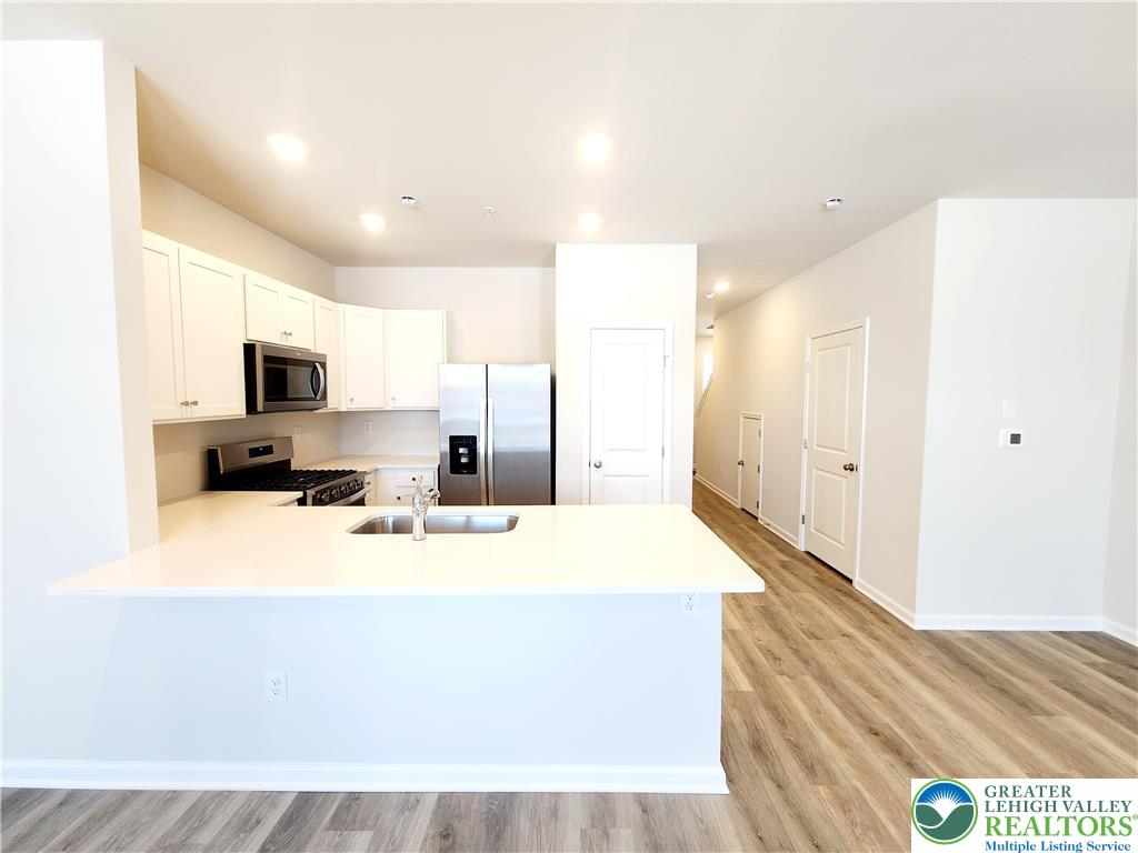 1104 Martin Road Breinigsville, PA 18031 - Photo 11 of 30 a large white kitchen with kitchen island a sink stainless steel appliances and cabinets
