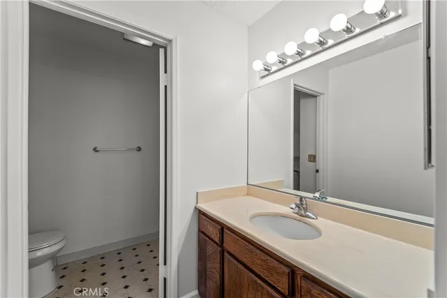 a bathroom with a sink a toilet and a mirror