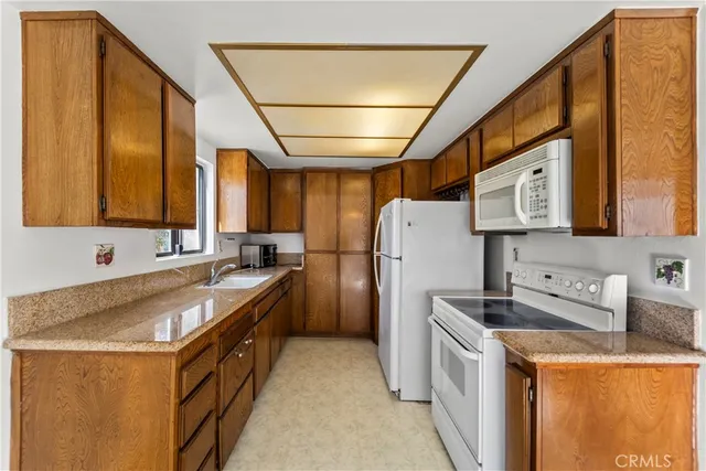 a kitchen with a refrigerator a stove a sink dishwasher and wooden cabinets with wooden floor