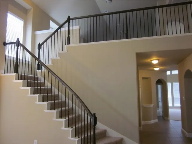 a view of staircase with railing and white walls