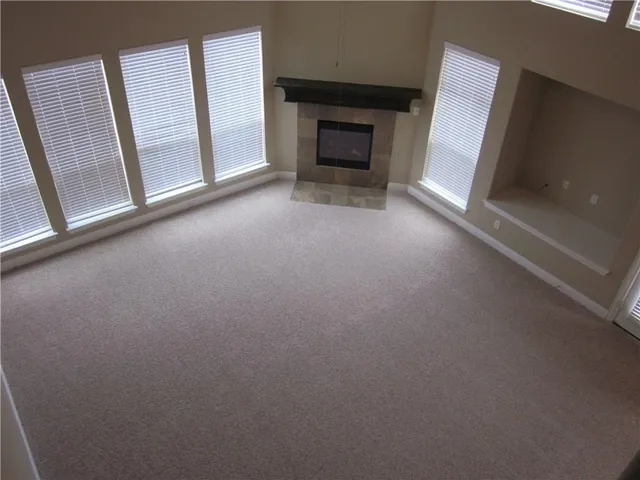 a view of an empty room with a fireplace and a window