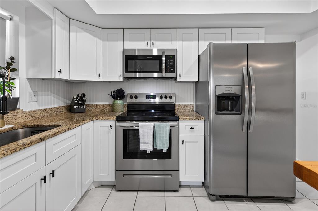 532 Center Road Venice, FL 34285 - Photo 39 of 68 a kitchen with stainless steel appliances granite countertop a refrigerator a stove and a sink