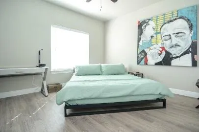 a bedroom with a bed and painting on the wall