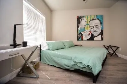 a bedroom with a bed and painting on the wall