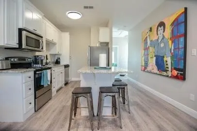 a kitchen with stainless steel appliances kitchen island granite countertop a stove a sink and a microwave