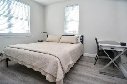 a bedroom with a bed a chair and a window