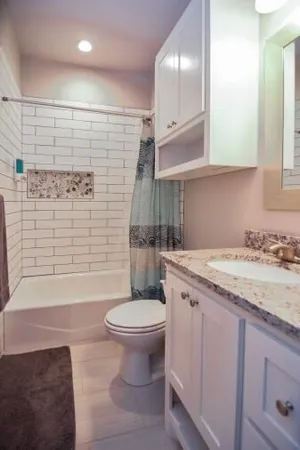 a bathroom with a granite countertop sink toilet and shower