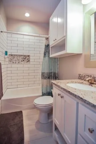 a bathroom with a granite countertop sink toilet and shower