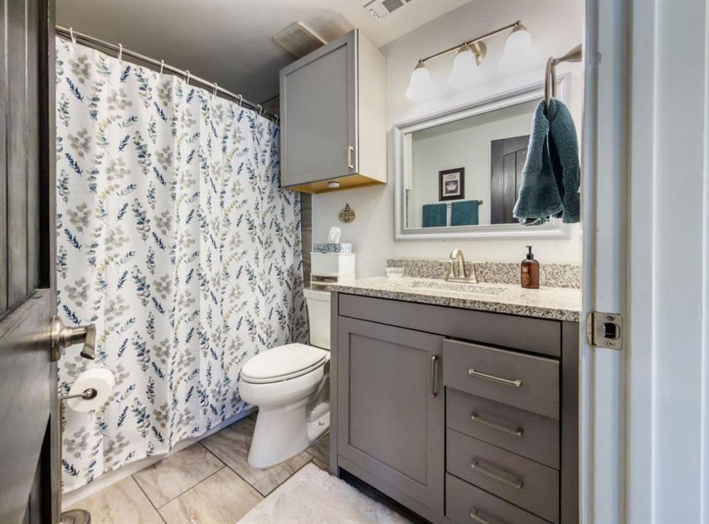 14275 Gholson Road Gholson, TX 76705 - Photo 14 of 22 Bathroom featuring a vanity with a granite-style countertop, undermount sink, and brushed nickel faucet