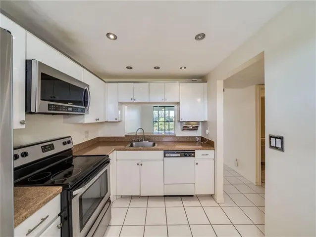 a kitchen with a sink stove top oven and cabinets