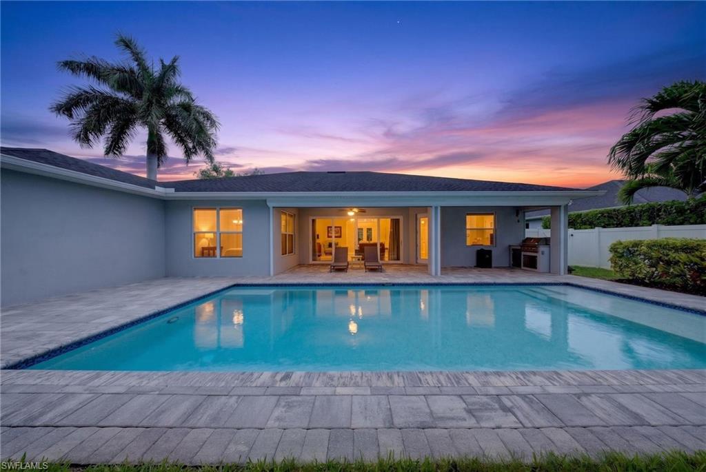 37 Johnnycake Drive Naples, FL 34110 - Photo 30 of 33 Backyard oasis featuring a rectangular swimming pool, surrounding paver patio, and lush landscaping