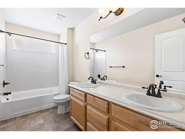 a bathroom with a sink a toilet a mirror a bathtub and shower