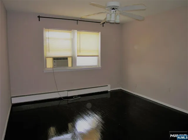 en empty room with wooden floor and windows