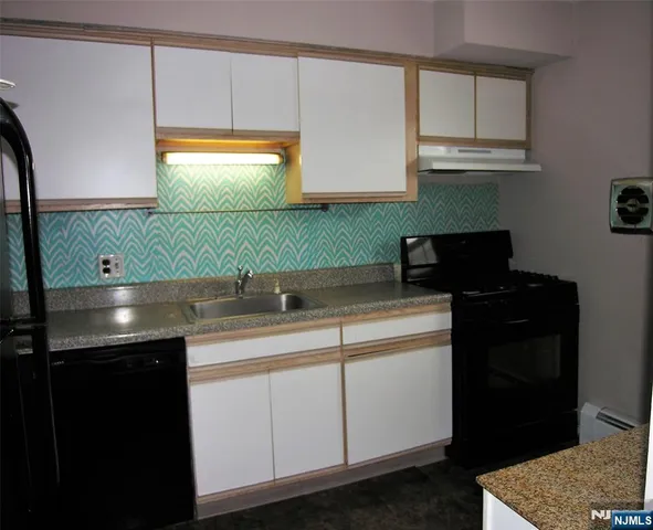a kitchen with a sink cabinets and a stove top oven