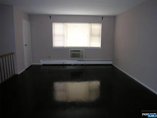 a view of a room with wooden floor and a window