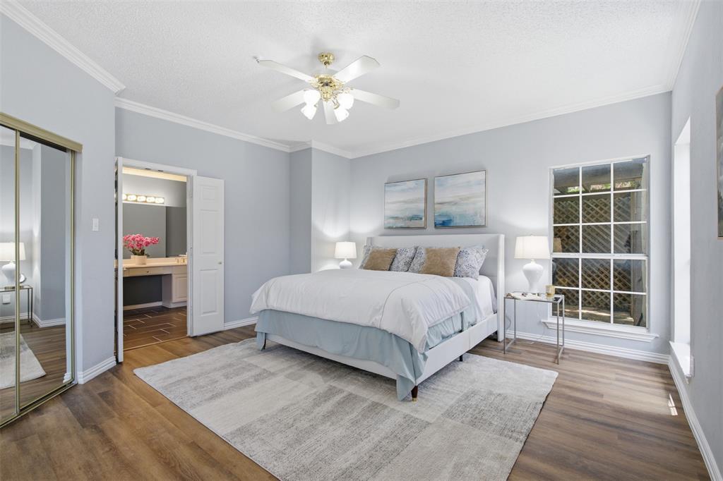 14584 Blueberry Court Addison, TX 75001 - Photo 21 of 40 a bedroom with a large bed and a chandelier