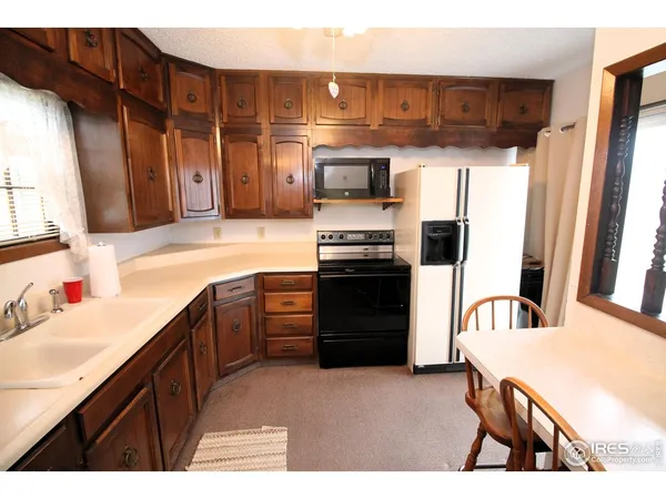 a kitchen with stainless steel appliances kitchen island granite countertop a refrigerator and a sink