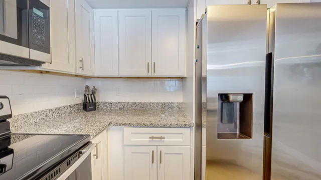a kitchen with granite countertop a sink and cabinets
