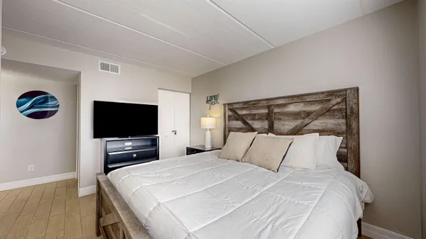 a bedroom with a bed and a flat screen tv