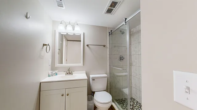 a bathroom with a toilet sink shower and mirror