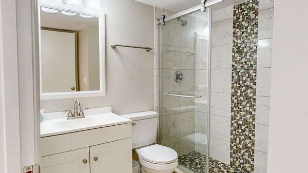 a bathroom with a sink a toilet and shower