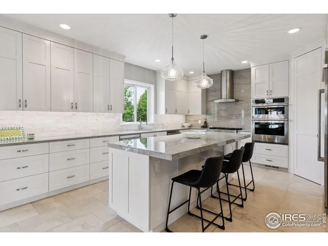a kitchen with granite countertop white cabinets and chairs