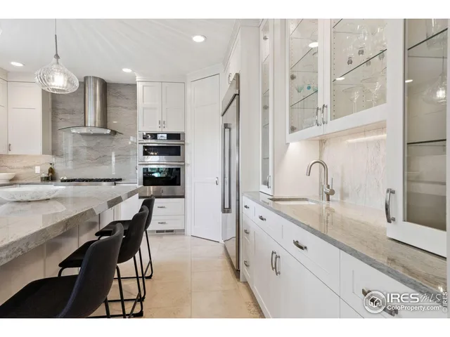 a kitchen with kitchen island granite countertop a sink cabinets and stainless steel appliances