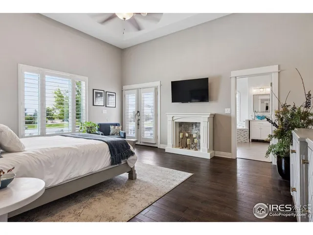 a spacious bedroom with a bed and a flat screen tv