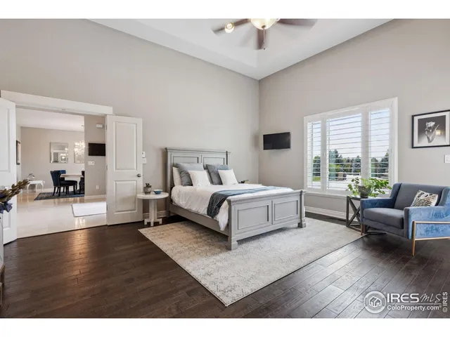 a bedroom with a bed wooden floor and windows
