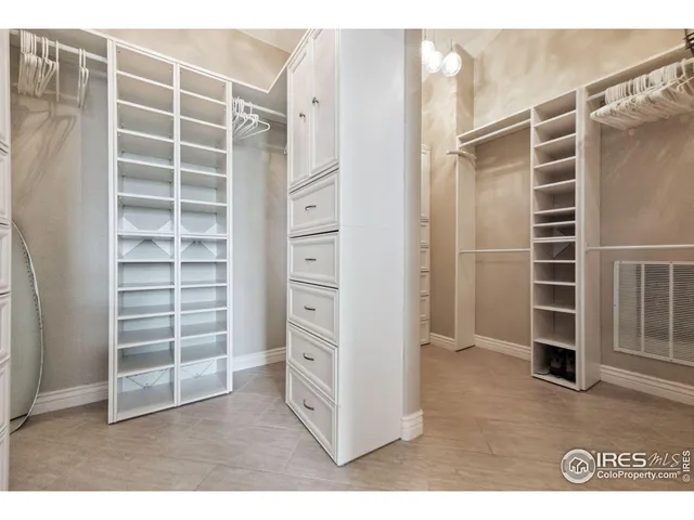 a view of walk in closet with clothes and shoes