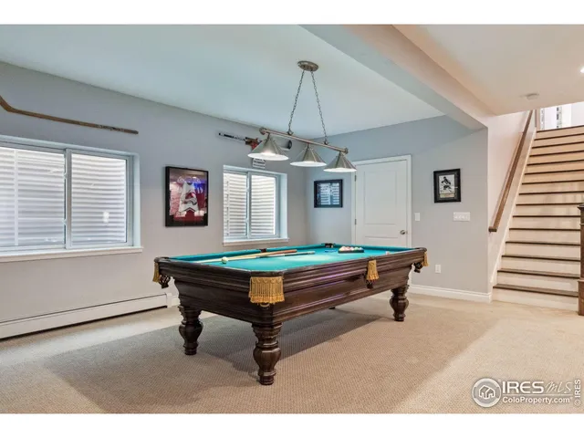 a room with pool table windows and wooden floor