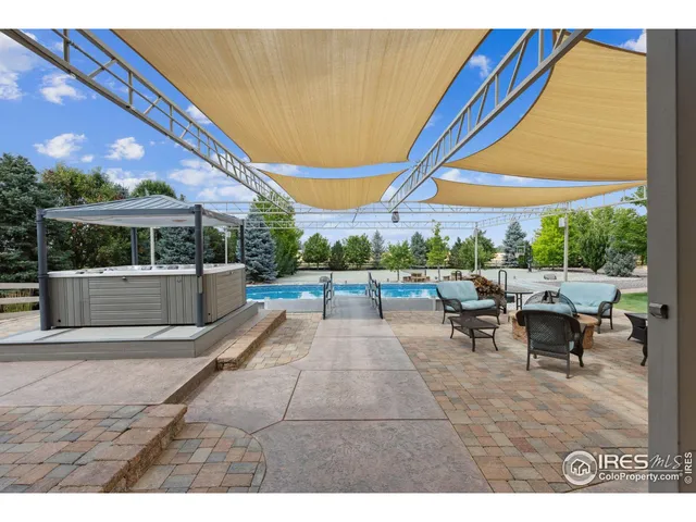 a view of a patio with table and chairs under an umbrella
