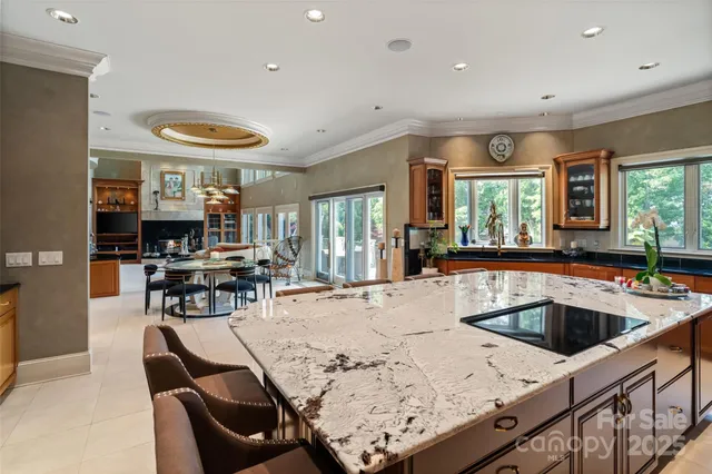 a kitchen with stainless steel appliances kitchen island granite countertop a sink and chairs