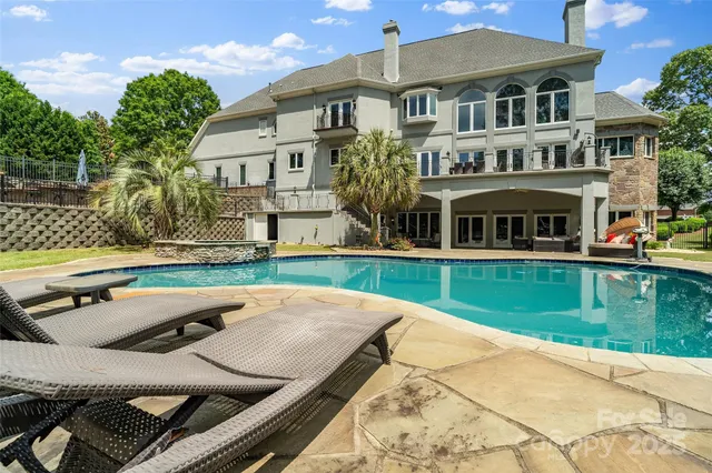 a view of a swimming pool with a patio and plants