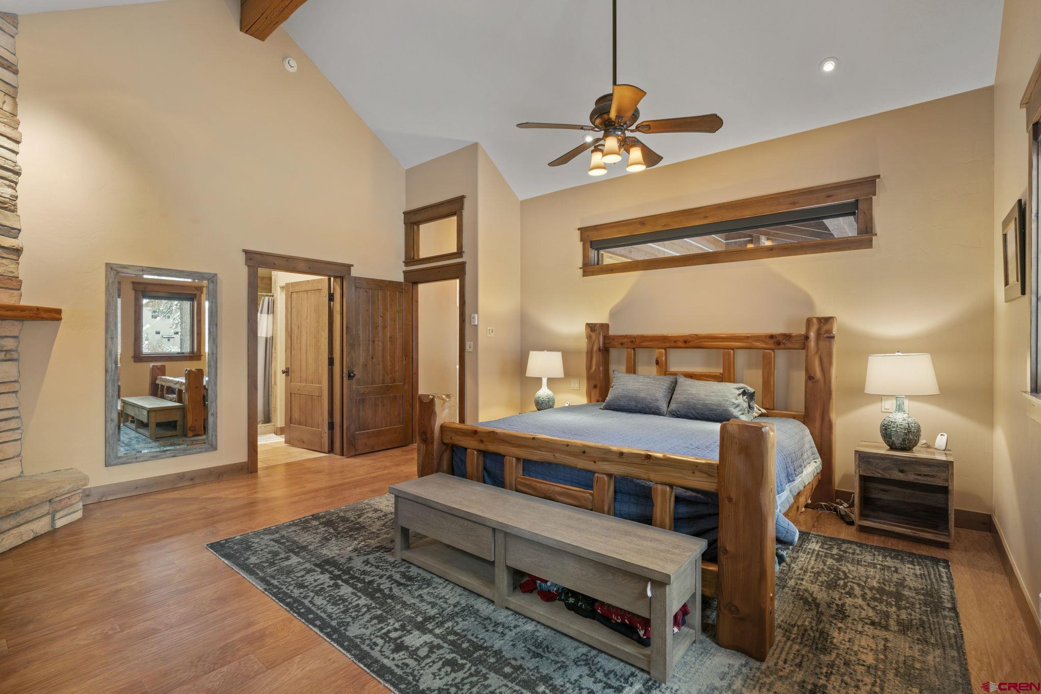 680 The Golden Dipper Road Durango, CO 81301 - Photo 15 of 35 a bedroom with a bed a mirror and a chandelier