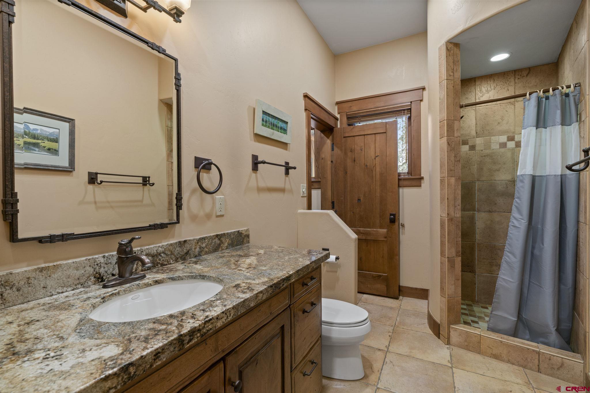 680 The Golden Dipper Road Durango, CO 81301 - Photo 21 of 35 a bathroom with a granite countertop sink toilet and shower