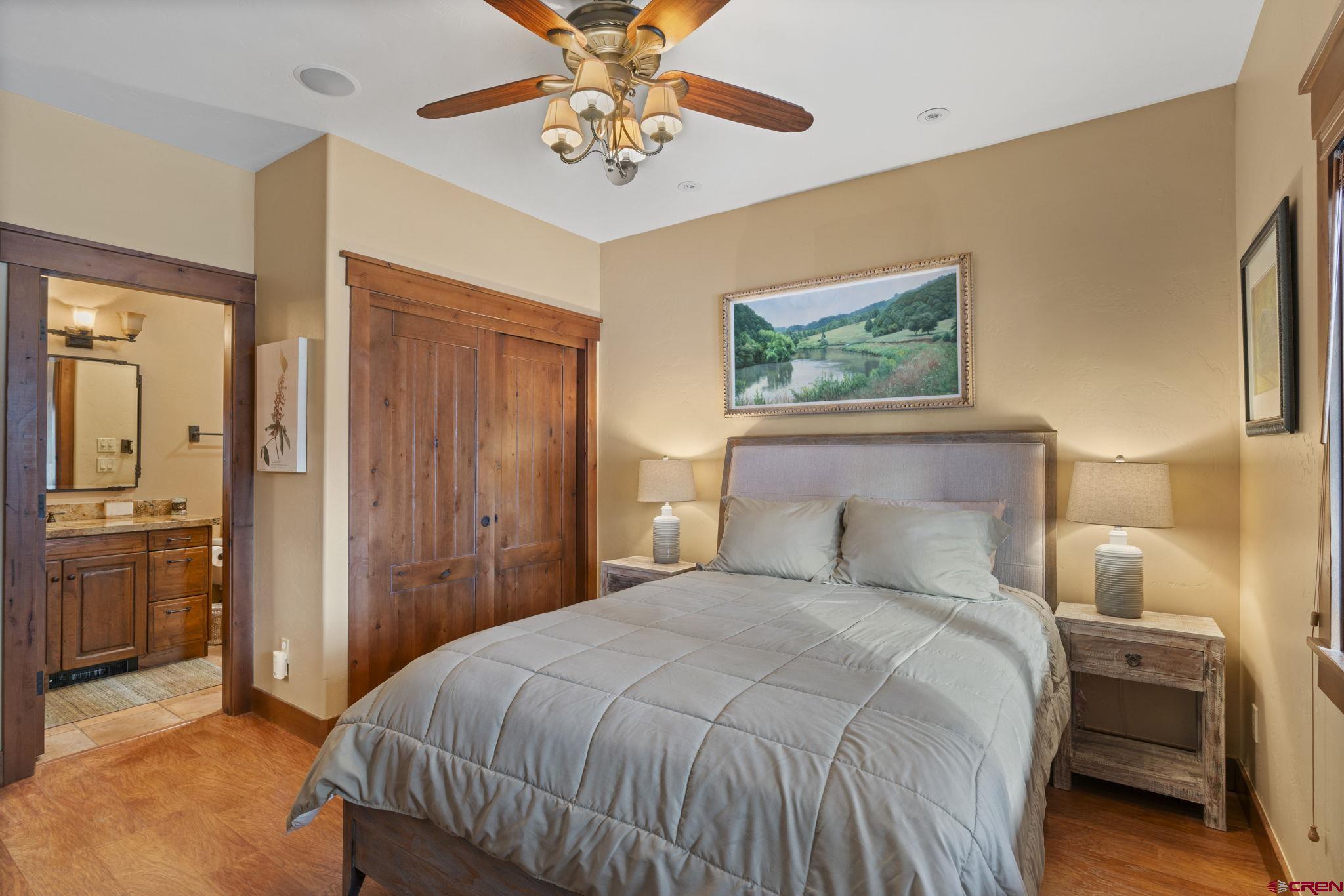 680 The Golden Dipper Road Durango, CO 81301 - Photo 32 of 35 a bedroom with a large bed and a chandelier
