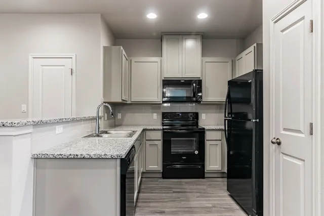 a kitchen with stainless steel appliances granite countertop a stove microwave and sink