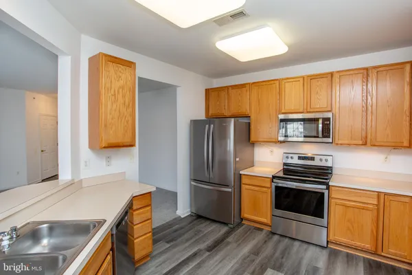 a kitchen with stainless steel appliances a stove a sink and a refrigerator
