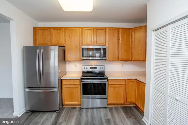 a kitchen with a refrigerator stove and wooden cabinets