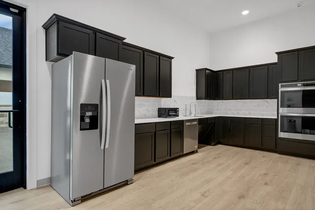 a kitchen with granite countertop a refrigerator and a stove top oven