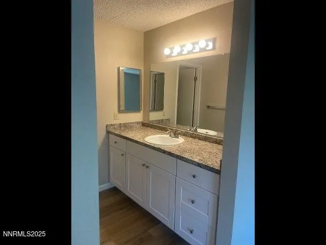 a bathroom with a granite countertop sink and a mirror