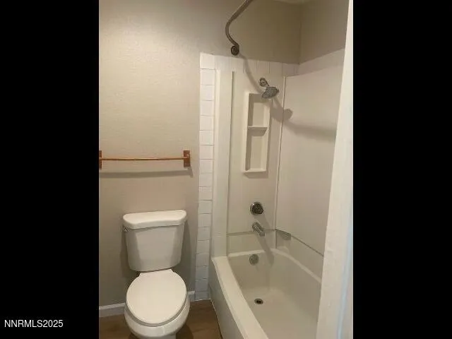 a white toilet sitting next to a bath tub