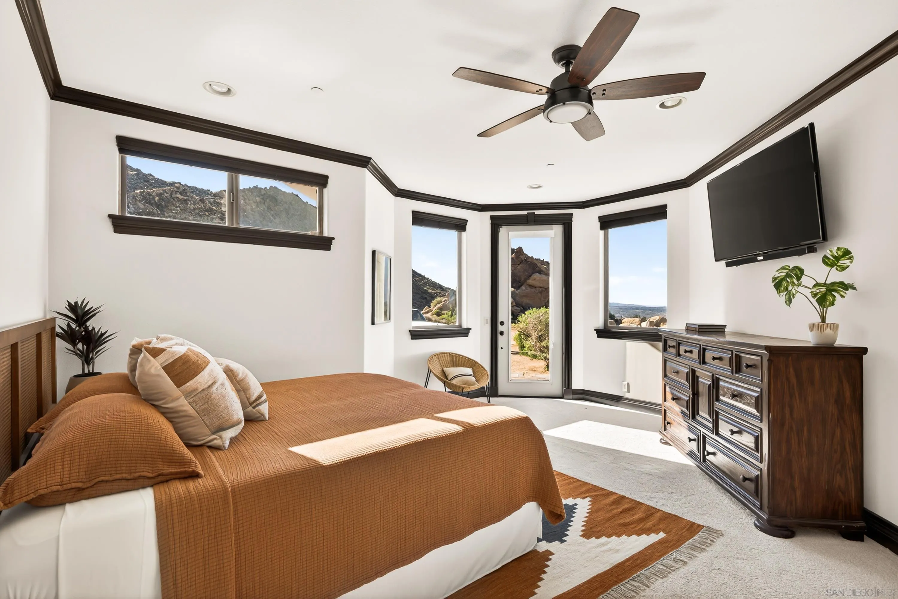 8022 Wesley Road Joshua Tree, CA 92252 - Photo 18 of 69 a bedroom with a bed a flat screen tv and couches